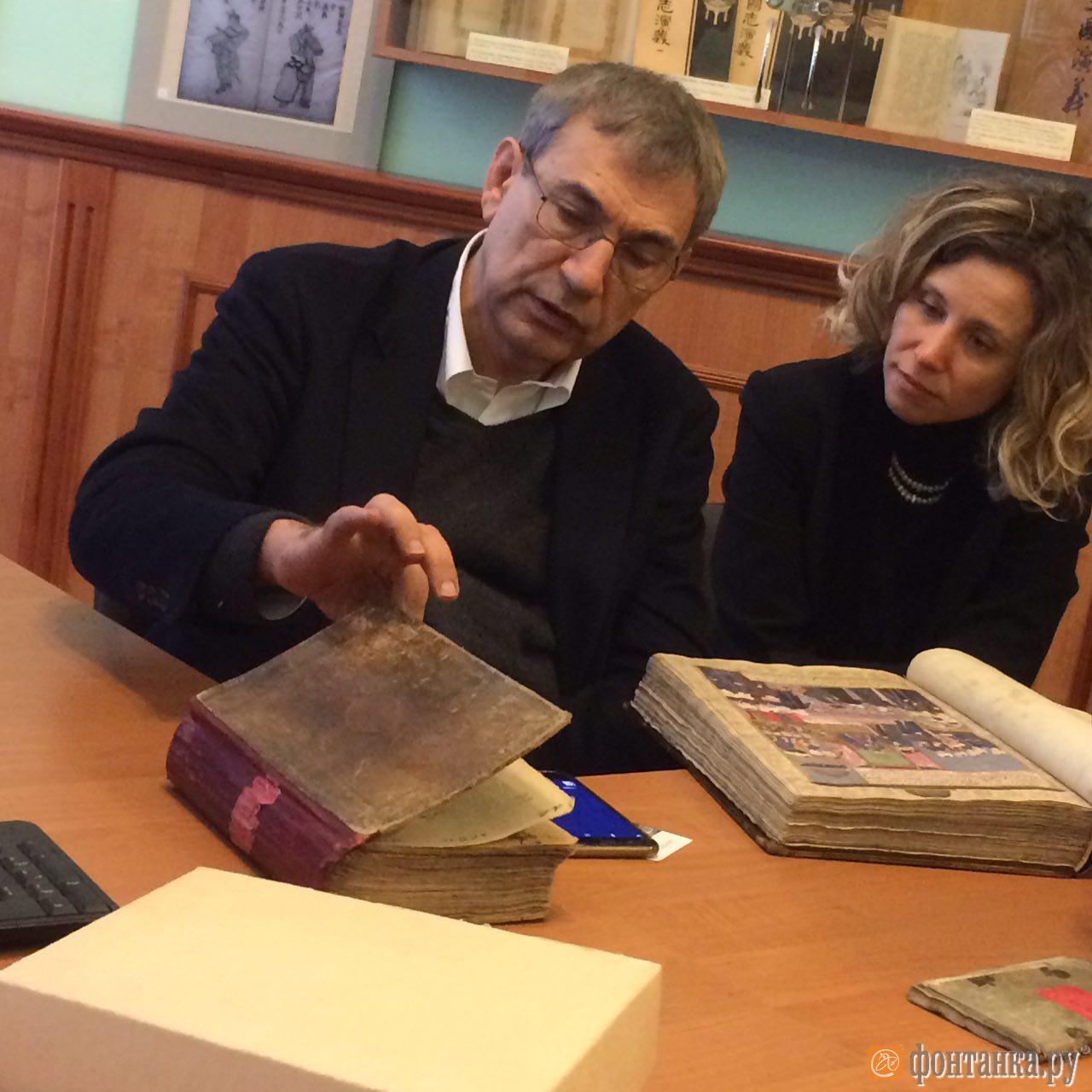 Орхан Памук, его супруга, и переводчик Аполлинария Аврутина рассматривают рукописи.